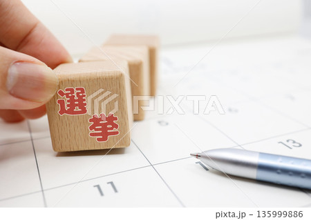 カレンダーに置かれた選挙ブロックと投票日程のイメージ。 カレンダーに置かれた選挙ブロックと投票日程のイメージ。 135999886