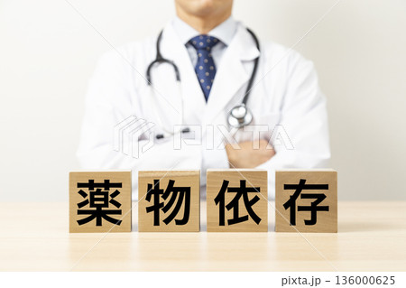 「薬物依存」と書かれたブロックと医師 136000625