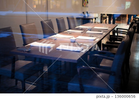 ガラス越しに並ぶレストランのテーブルセッティング 136000656
