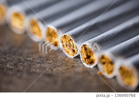 Extreme close-up of several cigarettes in a row showing tobacco texture and paper detail 136000768
