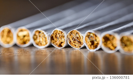 Extreme close-up of several cigarettes in a row showing tobacco texture and paper detail Extreme close-up of several cigarettes in a row showing tobacco texture and paper detail 136000781