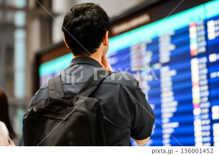空港で時刻表を確認する男性 ■撮影協力：関西国際空港（KIX） 136001452
