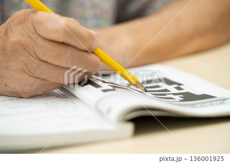 Bangkok, Thailand - May 15, 2022 elderly woman playing sudoku puzzle game. 136001925