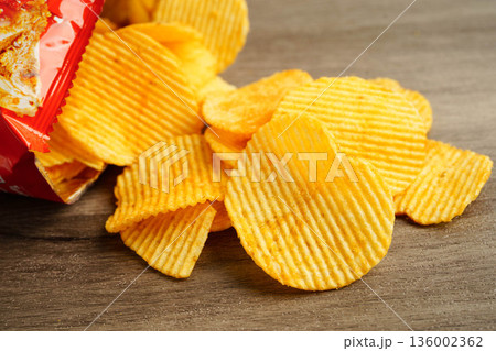 Potato chips in open bag, delicious BBQ seasoning spicy for crips, thin slice deep fried snack fast food. Potato chips in open bag, delicious BBQ seasoning spicy for crips, thin slice deep fried snack fast food. 136002362