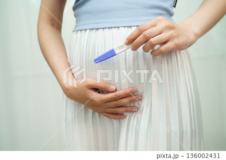 Asian holding pregnancy test for female of ovulation day, fetus, maternity, childbirth, birth control. Asian holding pregnancy test for female of ovulation day, fetus, maternity, childbirth, birth control. 136002431