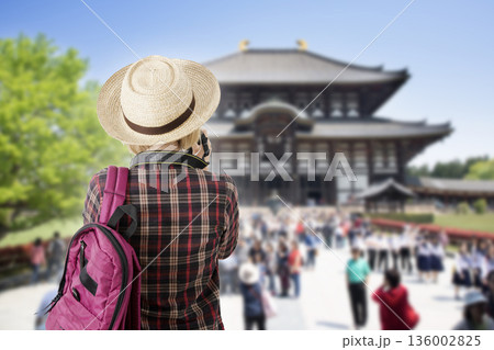 A tourist girl takeing a picture of a famous tourist attraction in Japan. A tourist girl takeing a picture of a famous tourist attraction in Japan. 136002825