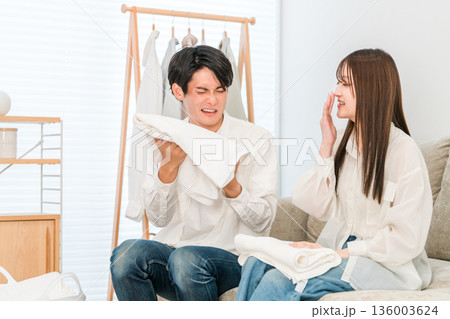リビングで洗濯物を畳む夫婦,カップル(生乾き,生乾き臭) リビングで洗濯物を畳む夫婦,カップル(生乾き,生乾き臭) 136003624