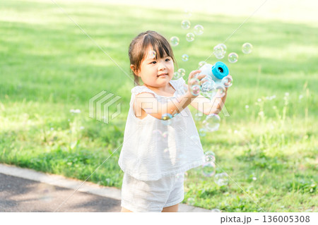 公園でシャボン玉で遊ぶ子供（ピクニック・キャンプ・アウトドア） 136005308