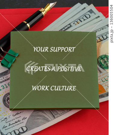 A green sticky note featuring the text YOUR SUPPORT CREATES A POSITIVE WORK CULTURE rests on several 100 US Dollar bills 136005504