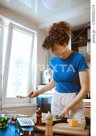 Preparation of smashed broccoli with cheese in a kitchen setting by a woman Preparation of smashed broccoli with cheese in a kitchen setting by a woman 136006224