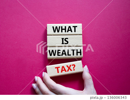 Tax symbol. Concept words What is Wealth Tax on wooden blocks. Beautiful bright red background. Businessman hand. Business and What is Wealth Tax concept. Copy space. 136006343