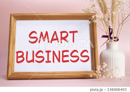 Smart business symbol. Concept words Smart business on beautiful wooden picture frame. Beautiful pink background with flower vase. Business and Smart business concept. Copy space. 136006403