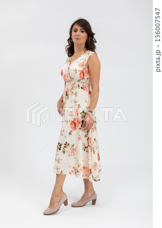 Elegant floral attire, Female model showcasing casual floral midi dress for campaigns, Seasonal fashion shoot featuring woman in soft floral outfit with relaxed stance Elegant floral attire, Female model showcasing casual floral midi dress for campaigns, Seasonal fashion shoot featuring woman in soft floral outfit with relaxed stance 136007547