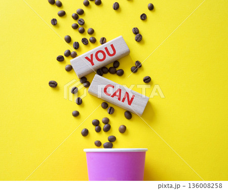 You Can symbol. Wooden blocks with words You Can. Beautiful yellow background with coffee cup and coffee beans. Business and You Can concept. Copy space. 136008258