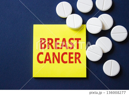 Breast cancer symbol. Concept word Breast cancer on yellow note. Beautiful deep blue background with pills. Medicine and Breast cancer concept. Copy space Breast cancer symbol. Concept word Breast cancer on yellow note. Beautiful deep blue background with pills. Medicine and Breast cancer concept. Copy space 136008277