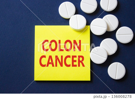 Colon Cancer symbol. Concept word Colon Cancer on yellow note. Beautiful deep blue background with pills. Medicine and Colon Cancer concept. Copy space 136008278
