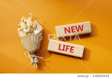 New life symbol. Concept word New life on wooden blocks. Beautiful orange background with bouquet of flowers. Business and New life concept. Copy space 136008410