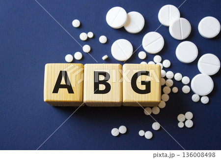 ABG symbol. Wooden cubes with words ABG Arterial Blood Gas. Beautiful deep blue background. Healthcare and Arterial Blood Gas concept. Copy space. 136008498