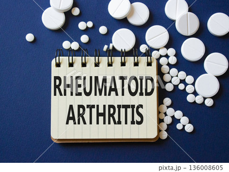 Rheumatoid Arthritis symbol. Concept word Rheumatoid Arthritis on notebook. Beautiful deep blue background with pills. Medicine and Rheumatoid Arthritis concept. Copy space Rheumatoid Arthritis symbol. Concept word Rheumatoid Arthritis on notebook. Beautiful deep blue background with pills. Medicine and Rheumatoid Arthritis concept. Copy space 136008605