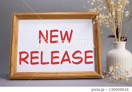 New Release symbol. Concept words New Release on beautiful wooden picture frame. Beautiful grey background with flower vase. Business and New Release concept. Copy space. 136008616