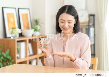 家でサプリメントを飲むミドルの女性 家でサプリメントを飲むミドルの女性 136008658