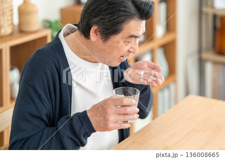 家でサプリメントを飲むミドルの男性 家でサプリメントを飲むミドルの男性 136008665