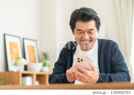 リビングでスマホを見るミドルの男性 136008703