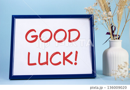 Good luck symbol. Concept words Good luck on beautiful wooden picture frame. Beautiful pink background with flower vase. Business and Good luck concept. Copy space. 136009020