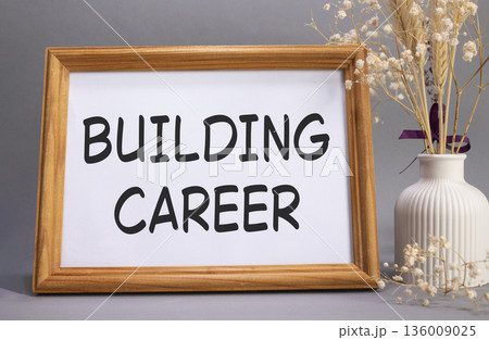Building Career symbol. Concept words Building Career on beautiful wooden picture frame. Beautiful grey background with flower vase. Business and Building Career concept. Copy space. Building Career symbol. Concept words Building Career on beautiful wooden picture frame. Beautiful grey background with flower vase. Business and Building Career concept. Copy space. 136009025