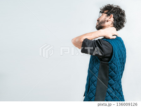 Suffering young man with stress and neck pain. Fatigued man with neck pain isolated Suffering young man with stress and neck pain. Fatigued man with neck pain isolated 136009126