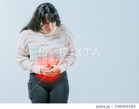 Female person holding stomach with digestive problems isolated. Sore Asian woman with digestive problems Female person holding stomach with digestive problems isolated. Sore Asian woman with digestive problems 136009169