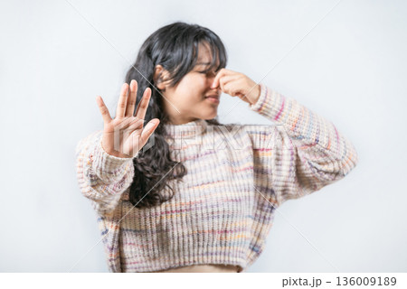 Bad smells: Asian woman covering nose because bad smells. Young woman with face of unpleasant odors, covering nose 136009189