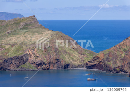 Baia dAbra coastal cliffs on Sao Lourenco Peninsula Madeira with anchored sailboats Atlantic sea 136009763