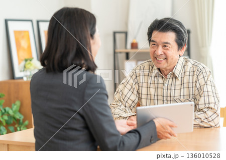 リビングで男性と商談をするビジネスウーマン 136010528