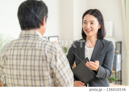 リビングで男性と商談をするビジネスウーマン 136010536