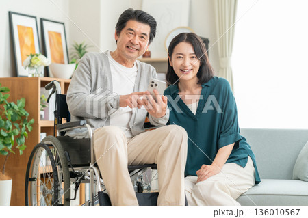 リビングでミドルの夫の介護する妻 リビングでミドルの夫の介護する妻 136010567