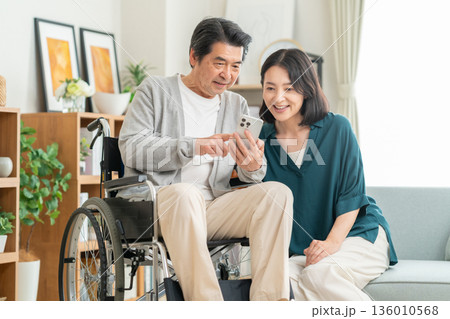 リビングでミドルの夫の介護する妻 リビングでミドルの夫の介護する妻 136010568