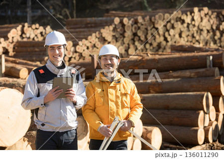 林業など第一次産業で働く人複数の人　ノギスで丸太を測る、不動産の建材材料のメージカメラ目線の笑顔 136011290