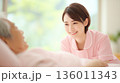 入居者に笑顔で接する若い女性の介護士 136011343