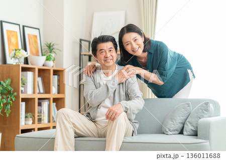 リビングでくつろぐミドルの夫婦 リビングでくつろぐミドルの夫婦 136011688
