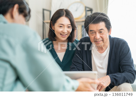 リビングでミドル夫婦と商談をする設計士 136011749