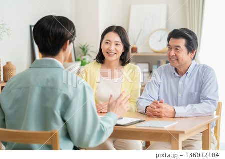 リビングでミドル夫婦と商談をする設計士 136012104