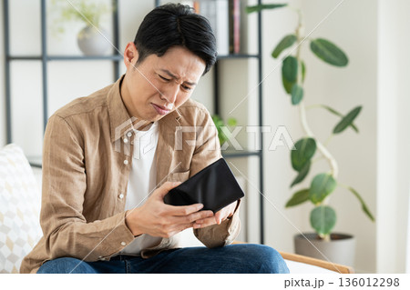 リビングで財布を持つミドルの男性　 136012298