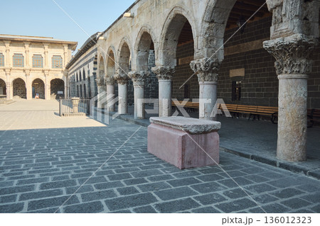 Stone arcade courtyard with arches and sarcophagus 136012323
