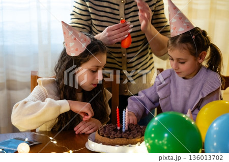 Celebration of friendship and joy during a festive birthday gathering for two adorable girls at a cozy home on a sunny afternoon filled with laughter and warmth 136013702