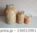 Sauerkraut in glass jars for fermentation, showing traditional homemade pickled cabbage with carrots, a healthy probiotic food for gut health and preservation 136013961