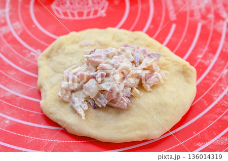 パン生地に具材を詰める 136014319