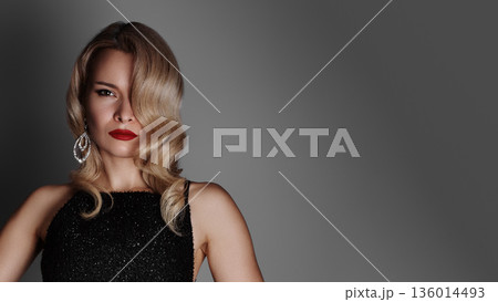 Confident Red Carpet Pose Showing Actress In Sequined Gown, Hands On Hips, Strong Posture, Bold Red Lips, Oversized Chandelier Earrings, Spotlight Glow, Neutral Backdrop, Lifestyle Glamour, Arrival 136014493