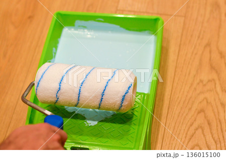 The cylindrical roller absorbs rich blue color from the plastic tray, getting loaded with paint and poised to glide smoothly across the interior surface for a new look. 136015100