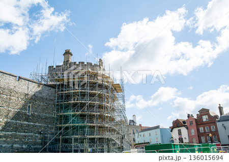 明るい青空と浮かぶ雲の下の工事のための足場が組まれ歴史的な石造りのウィンザー城 ロンドン郊外の街並み 明るい青空と浮かぶ雲の下の工事のための足場が組まれ歴史的な石造りのウィンザー城 ロンドン郊外の街並み 136015694